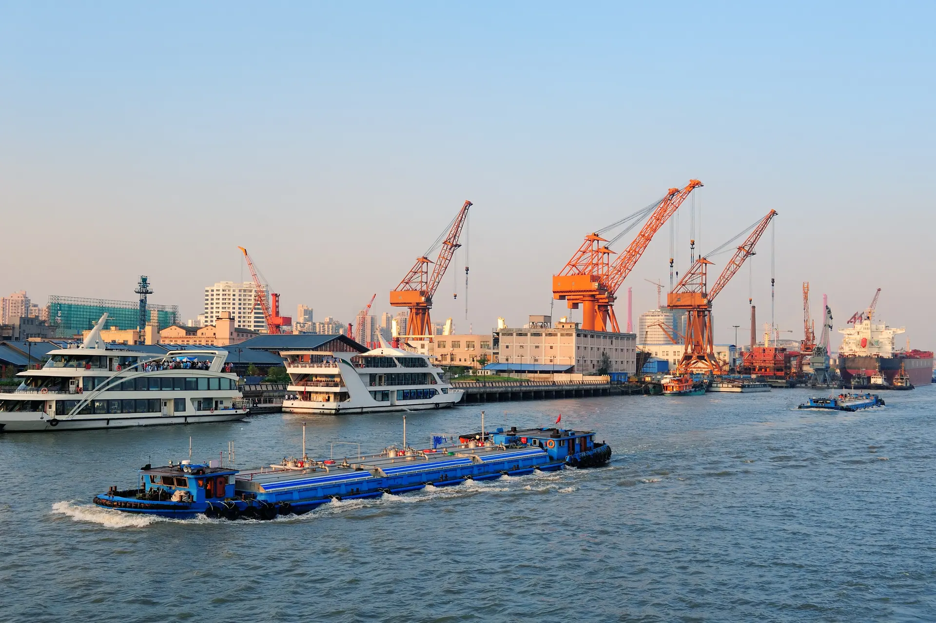 Dredging barge on the river in front of harbour cranes